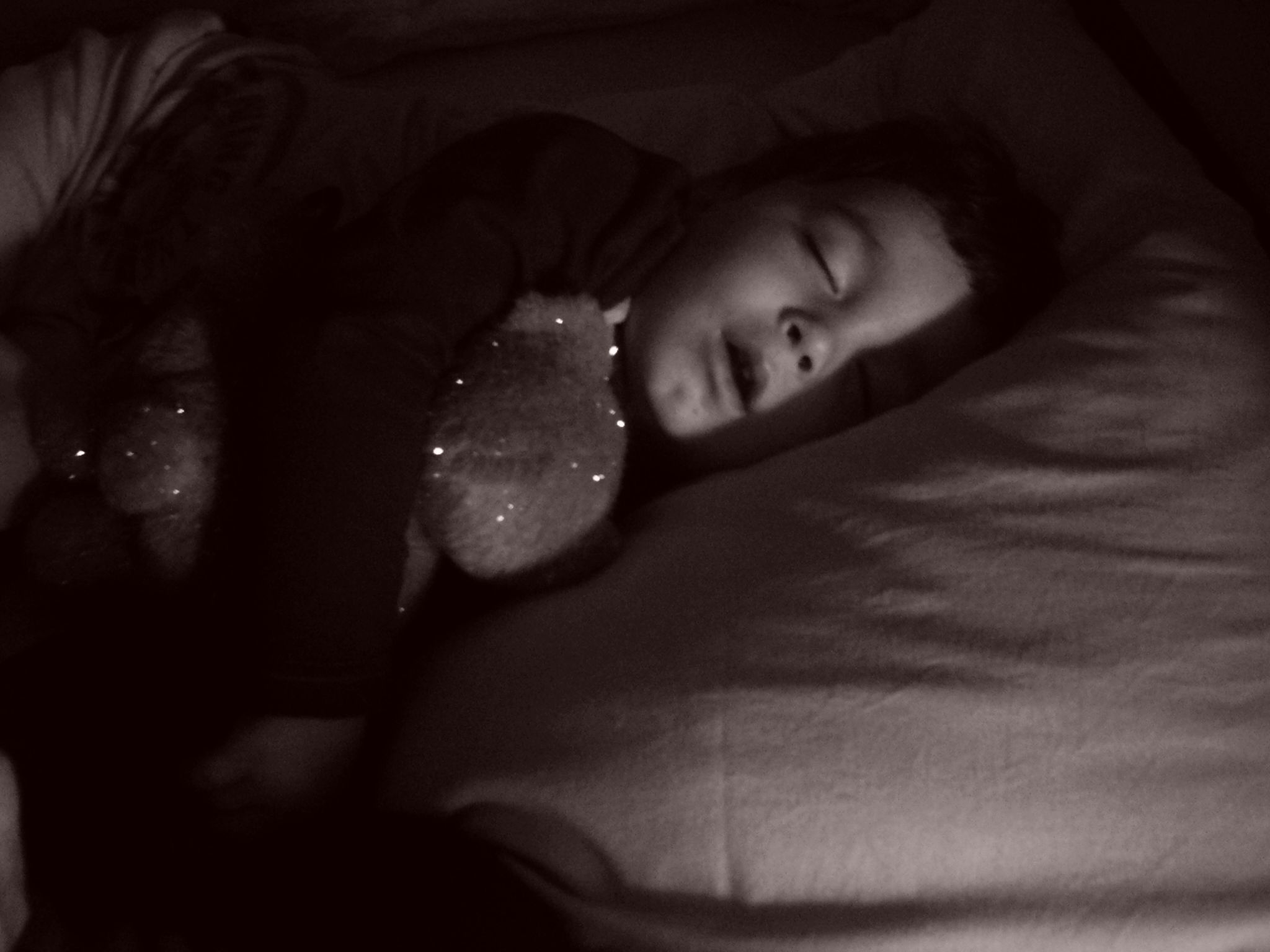 a young child is sleeping with her stuffed bear