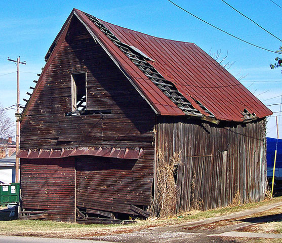 an old barn sitting in the middle of a town