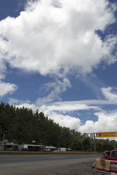 a truck on a road under a partly cloudy sky