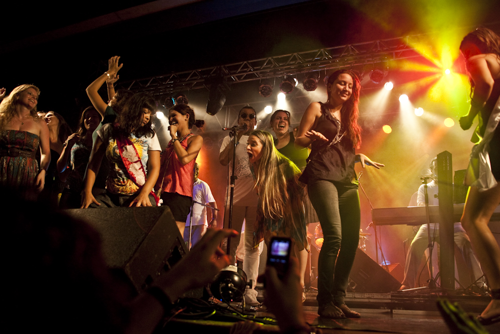 the women are on stage while watching a band play