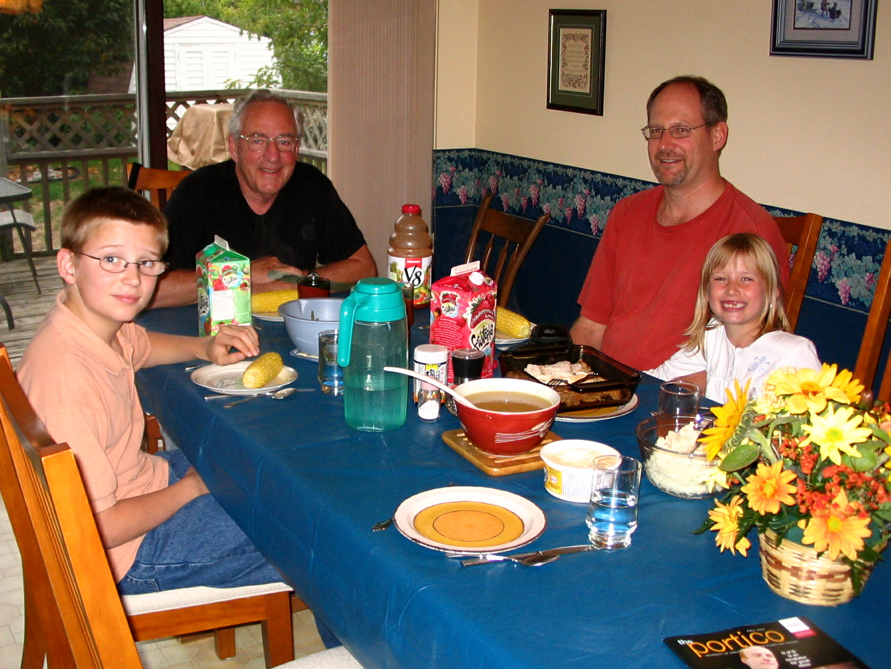 three adults and two children sit at a dining table