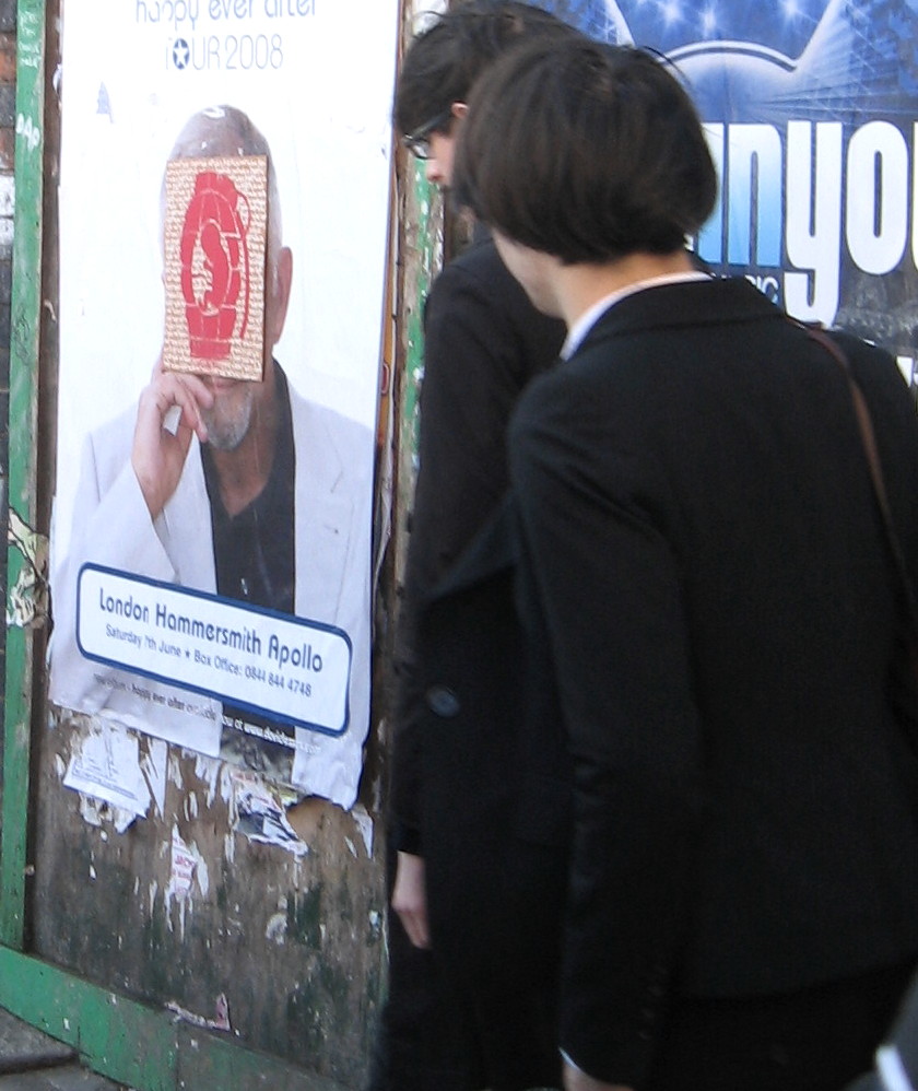 a woman is looking at a billboard with a man in it