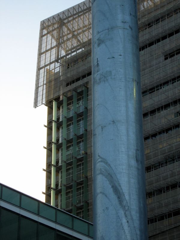 there is a stop sign next to a building with a net covering