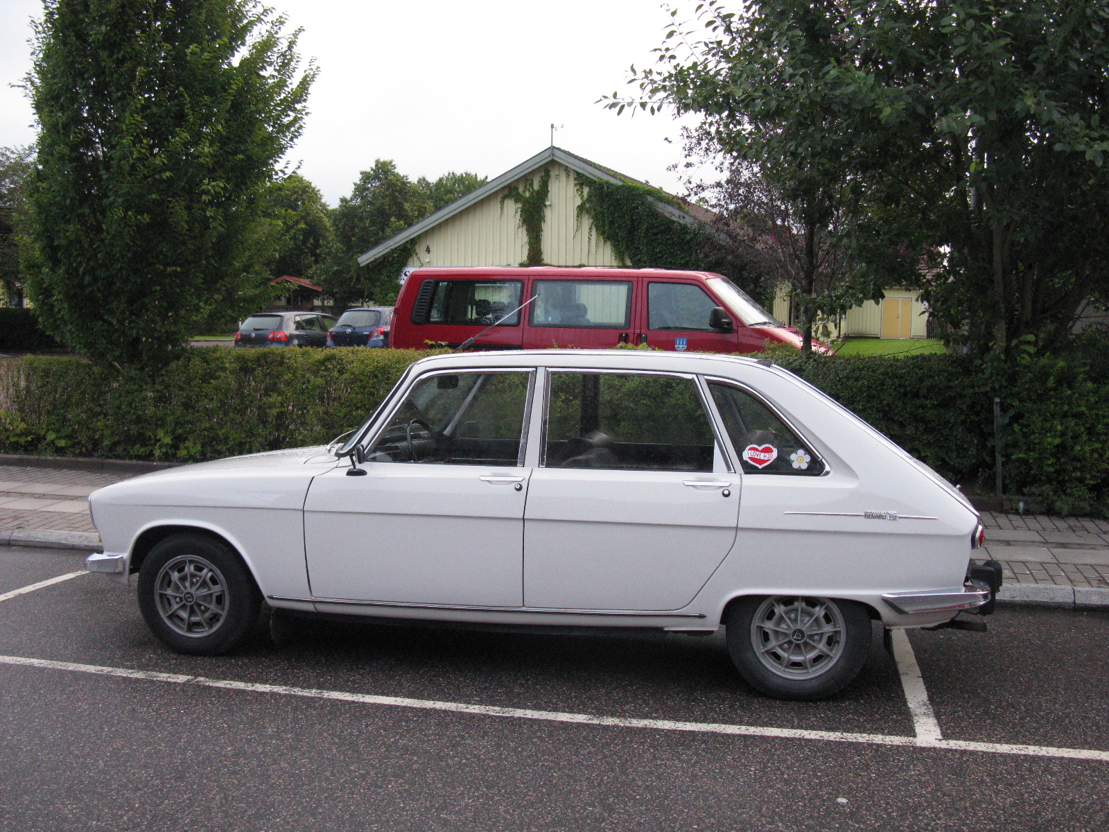 an old station wagon parked in a small parking lot