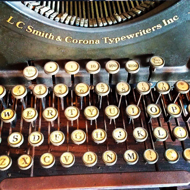 an old typewriter is sitting with yellow letters