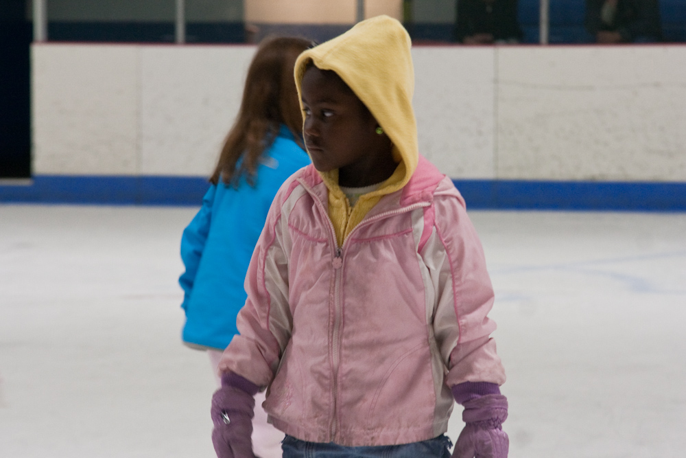 two young people are standing on an ice rink