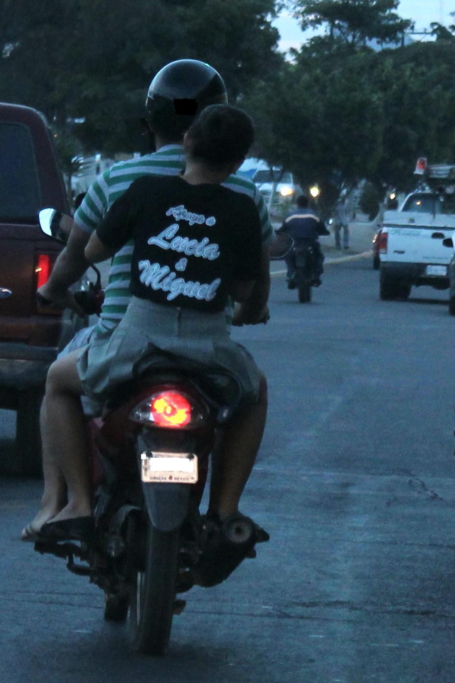 two people on a motorcycle riding down the road