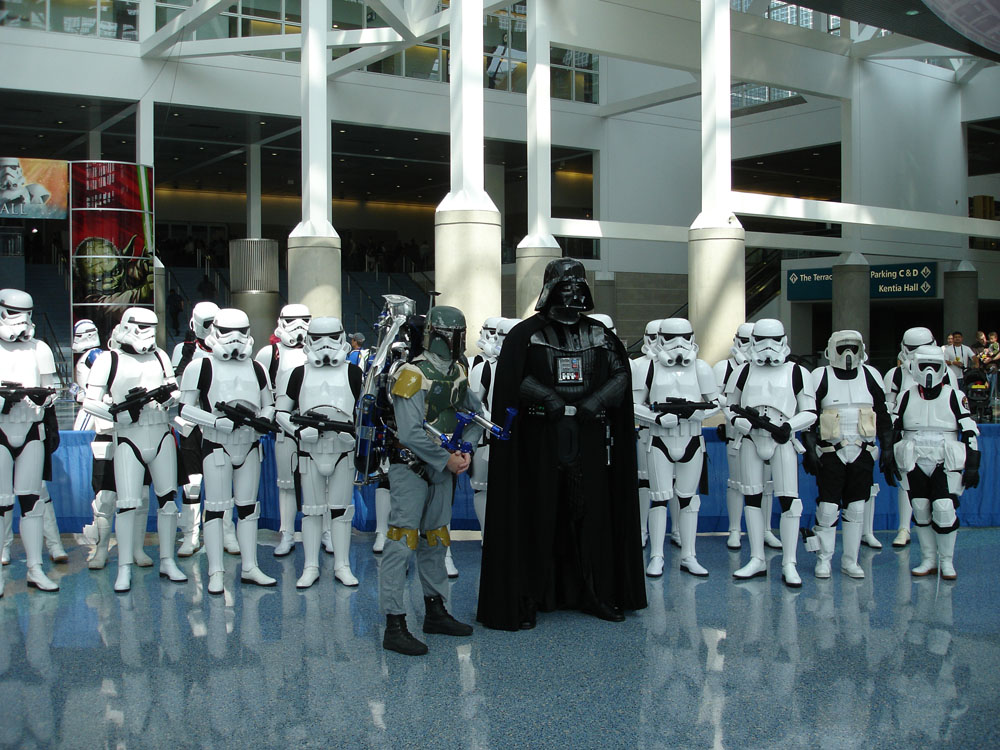 a group of star wars characters lined up in front of a building