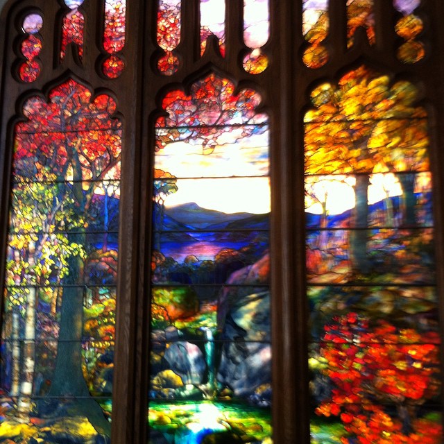 colorful stained glass window showing the scenery and trees