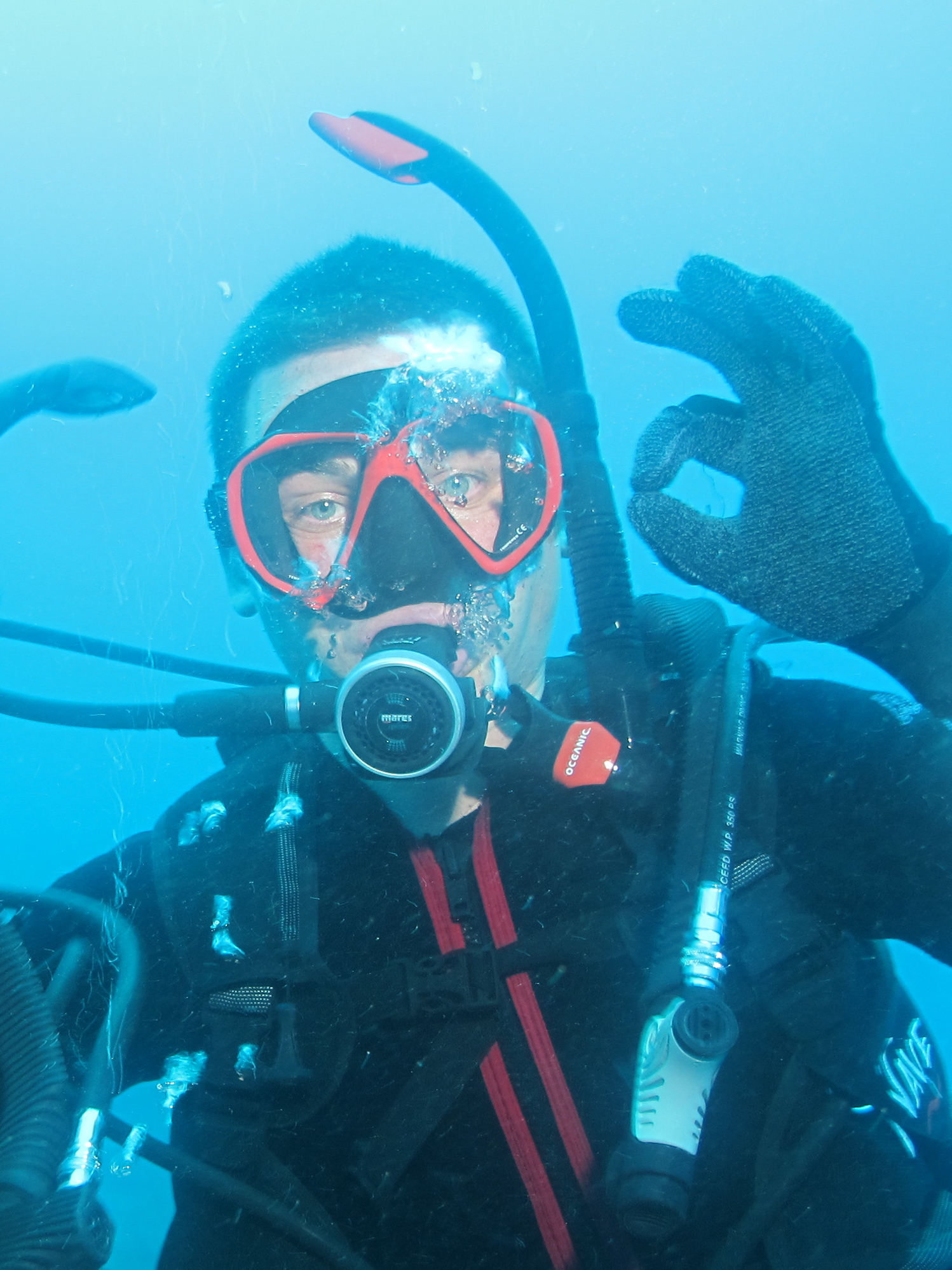 a man wearing scuba equipment is giving the v sign