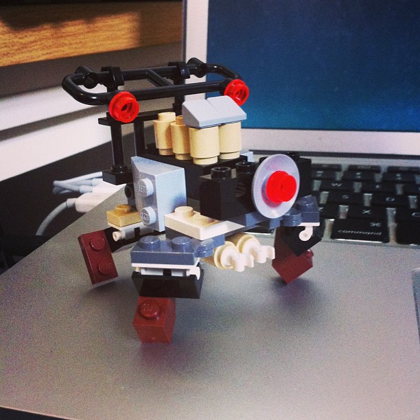 a very small lego robot is on the desk