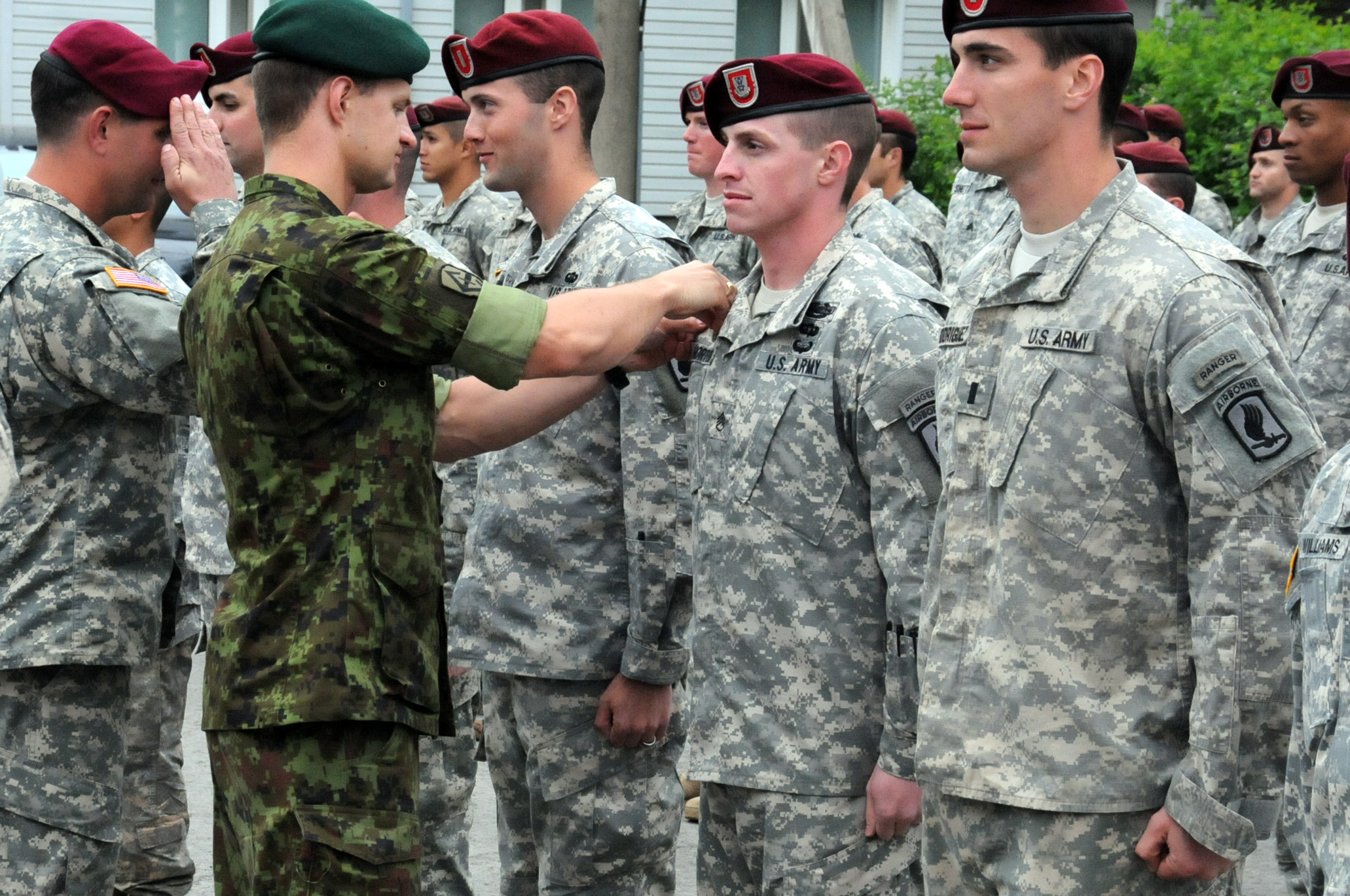 a man is shaking hands with some other people in uniform