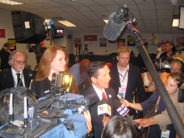 a news reporter talking to some journalists in a building