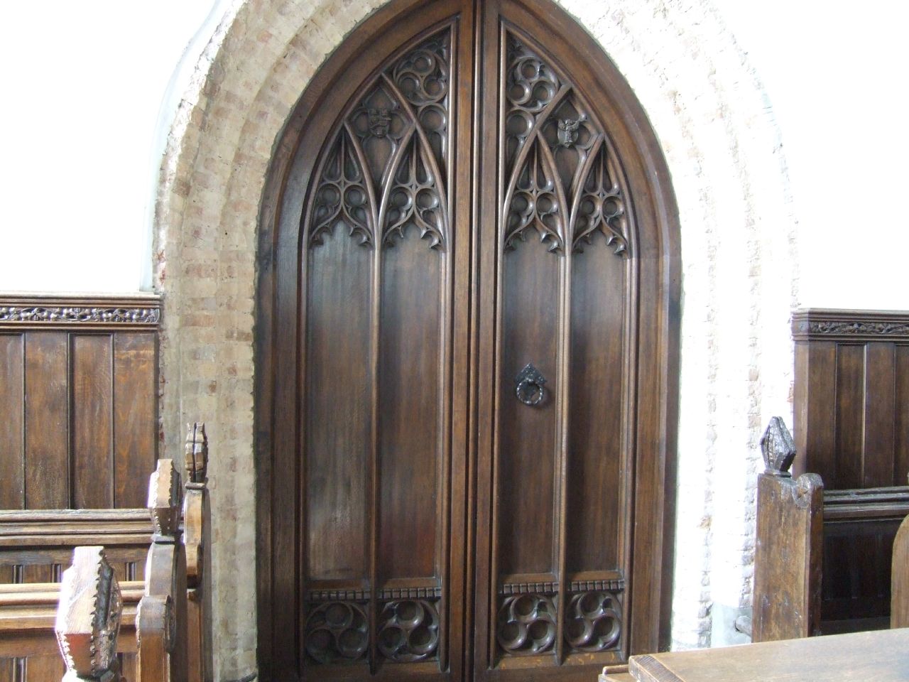 a large brown double wooden door in a room