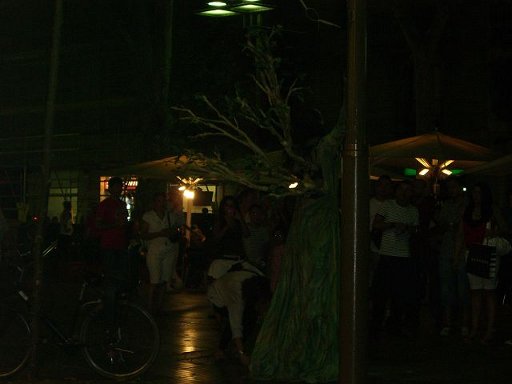 people are standing around at night under umbrellas