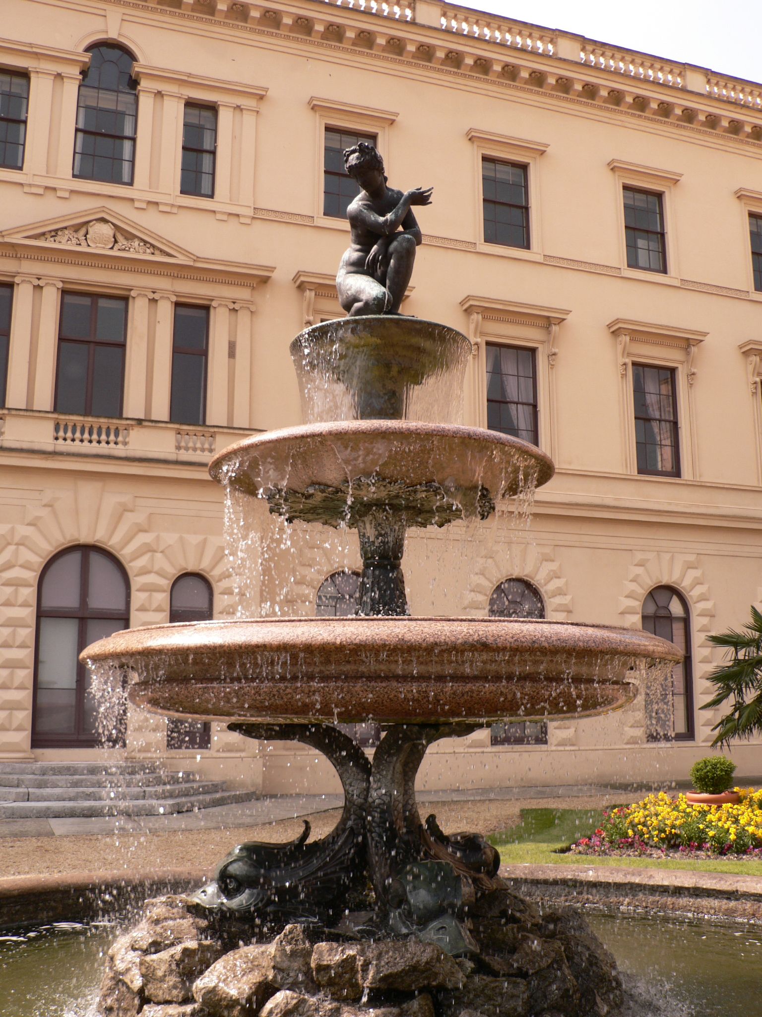 the water fountain has a little statue of a boy sitting on top