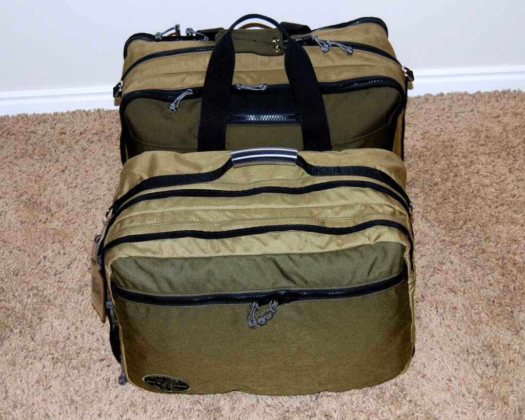a beige and black duffle bag with a tag on the bottom