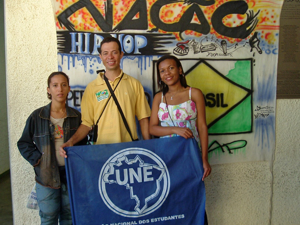 three people standing next to each other in front of a banner