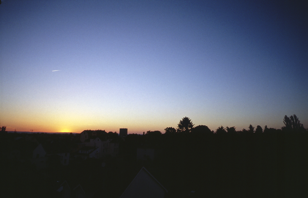 a view of a city at sunset from an apartment