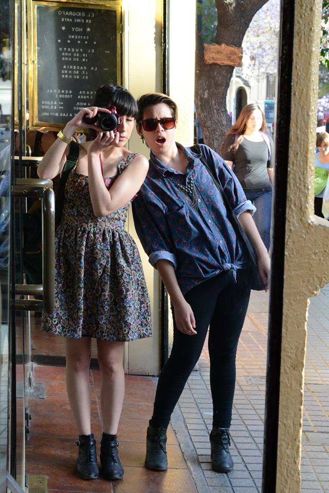 two women are standing outside looking at the camera