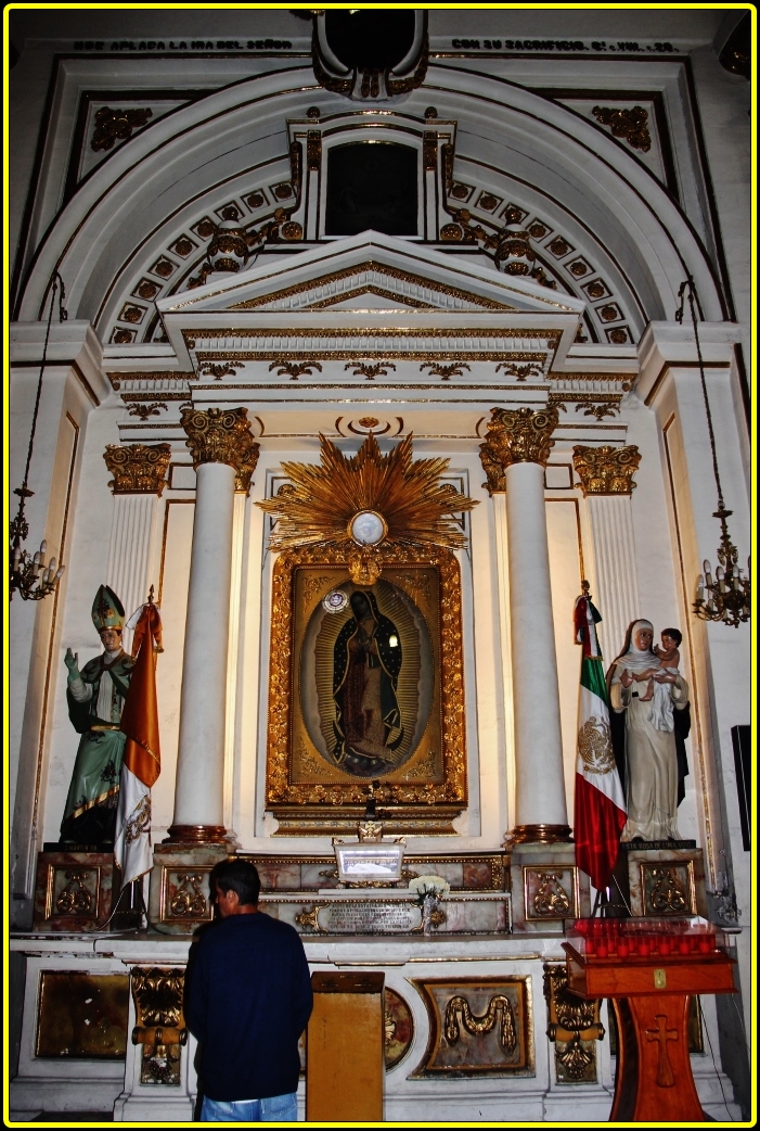 a man standing by a statue in a building