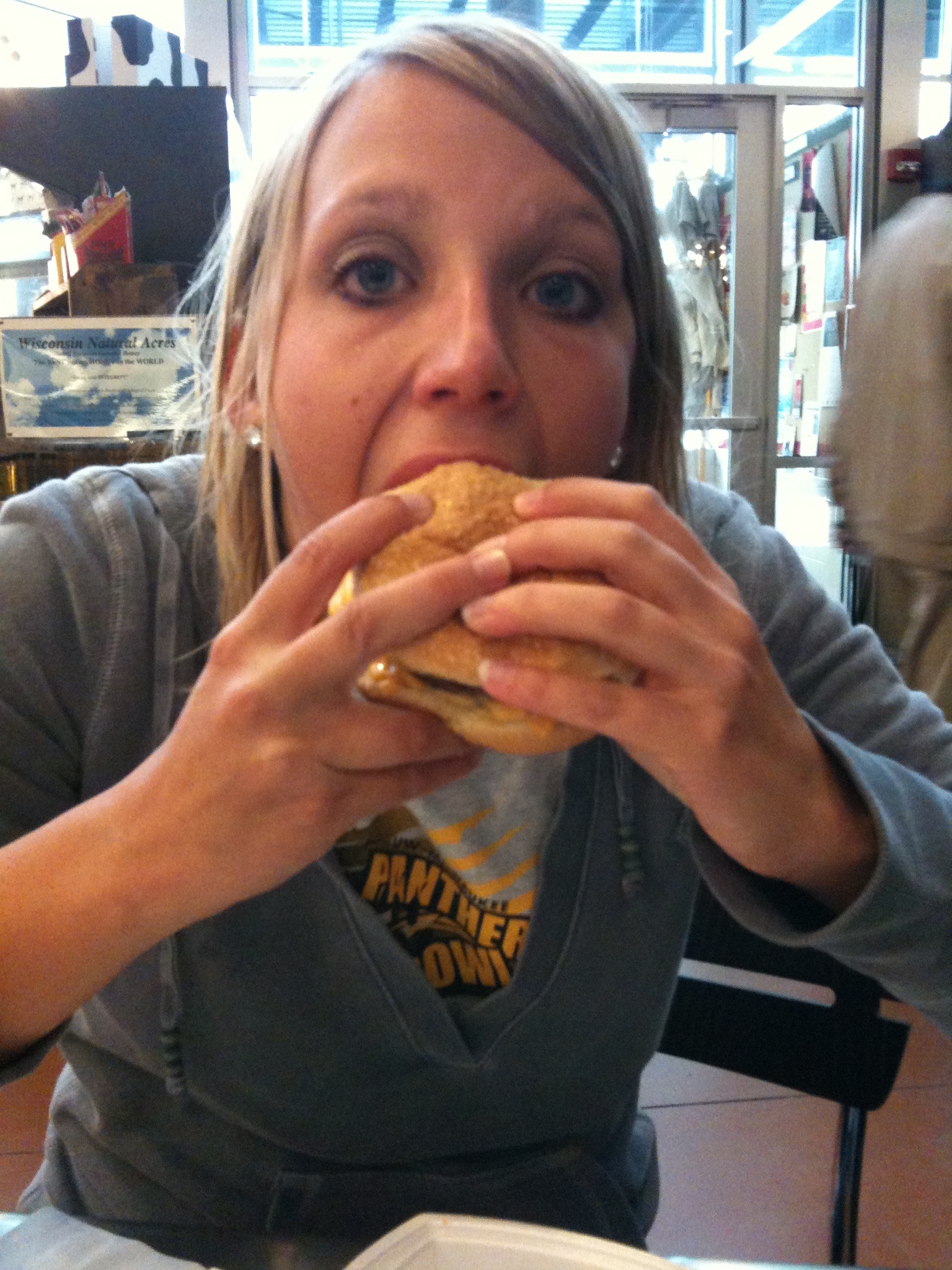 a woman takes a bite out of a sandwich