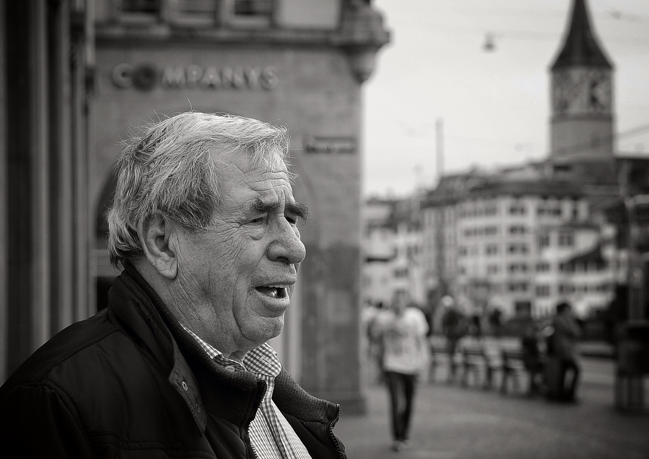 a man standing on a city street with a building in the background