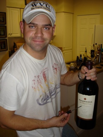 a man in a white hat holding a wine bottle