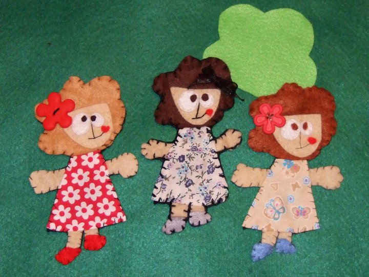 a group of dolls are posed next to a green background