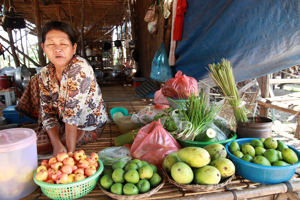 an old lady sitting in front of some baskets full of fruit