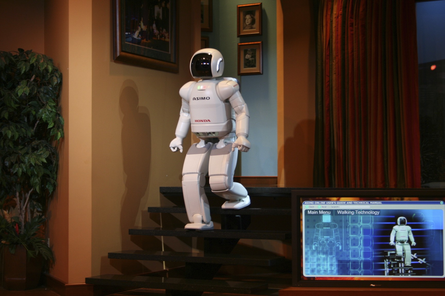 a robot suit sits on a stair way with a monitor