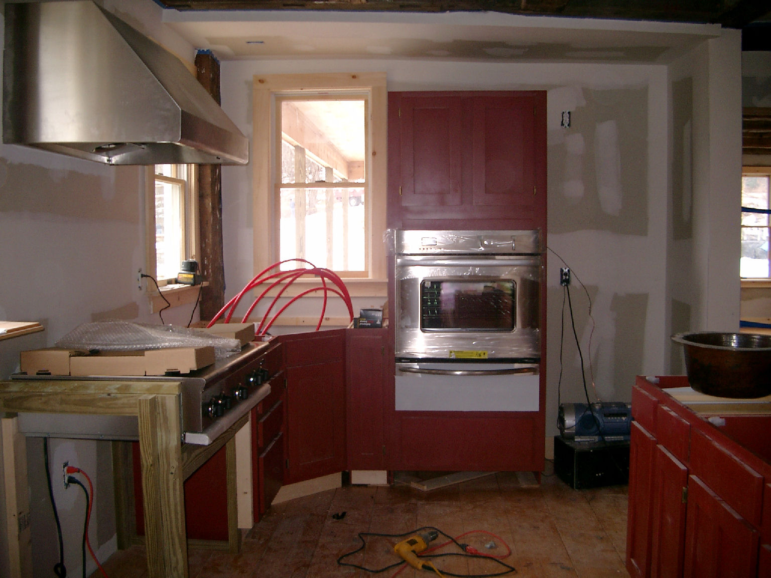 a kitchen under construction that has a lot of wooden cabinets