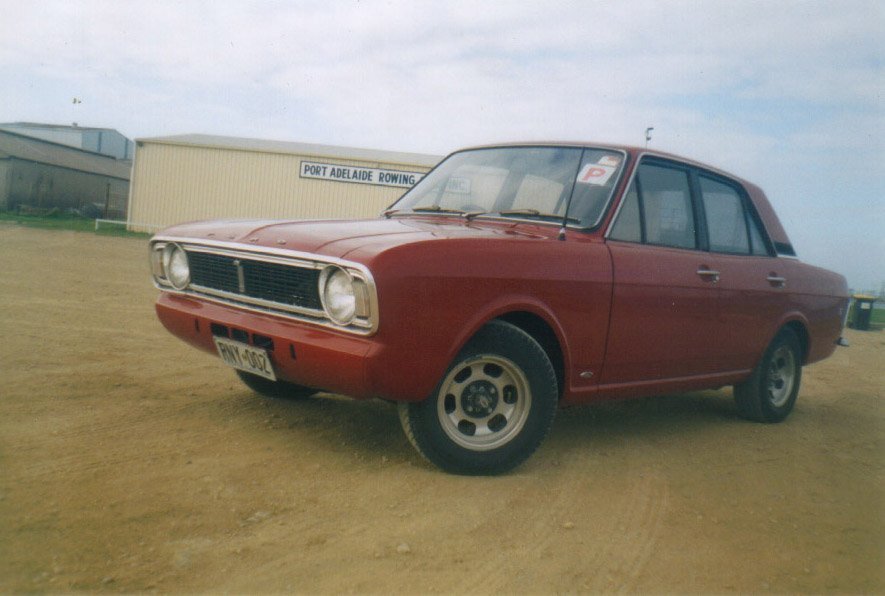 a red car that is sitting on dirt