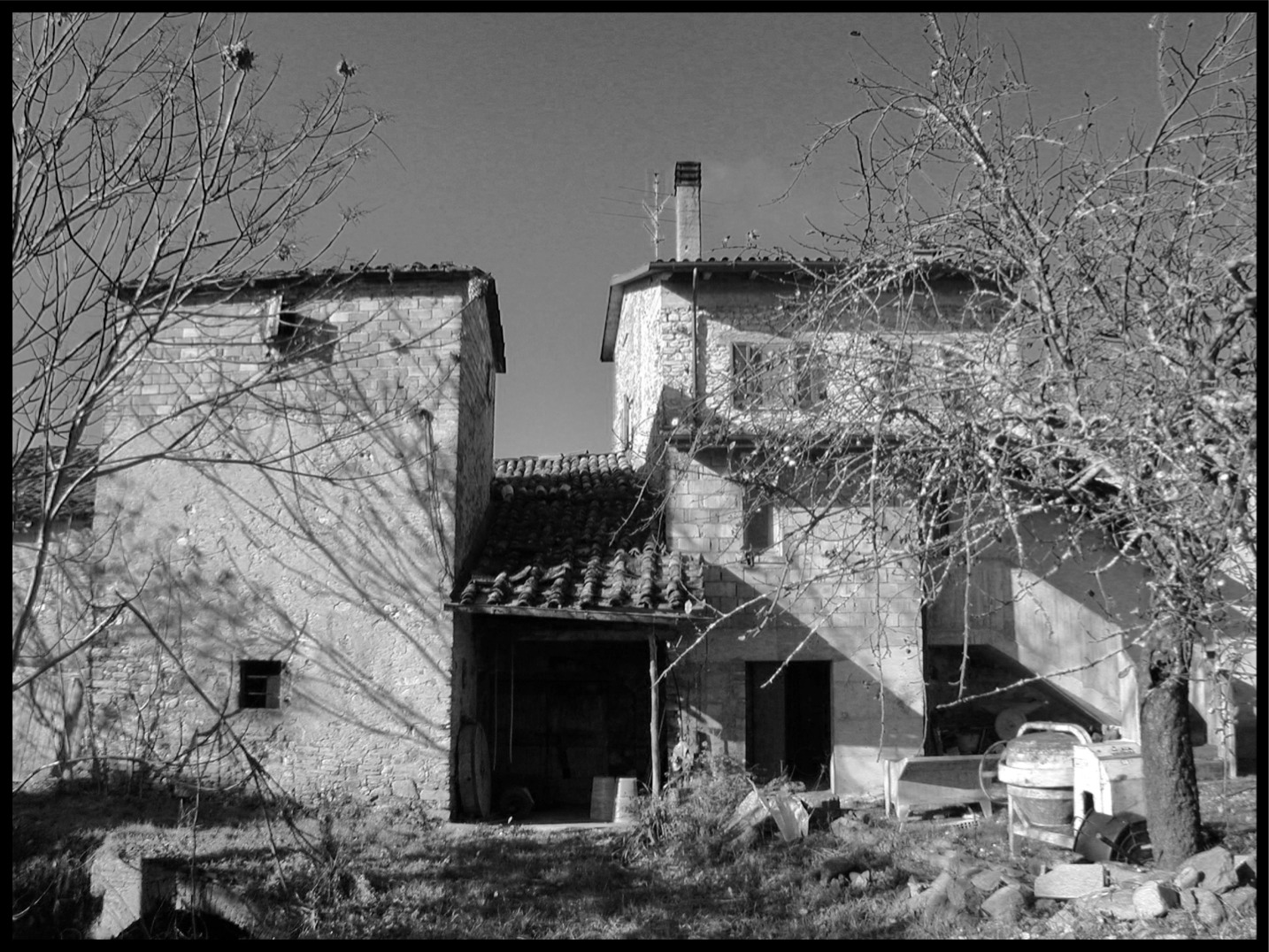 the back of an old house sitting under a tree