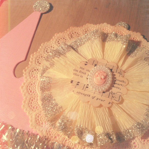 an ornate pink doily with a small decorative brooch