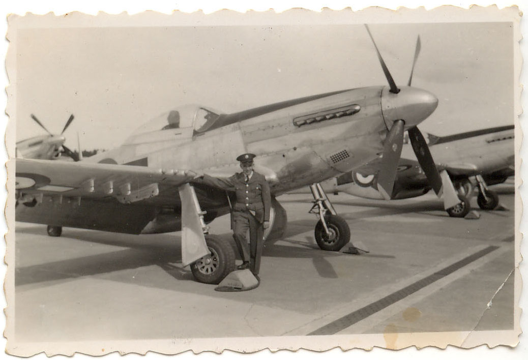 an old black and white po of a man standing next to a biplane