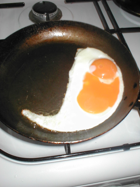 two fried eggs sitting in a cast iron set