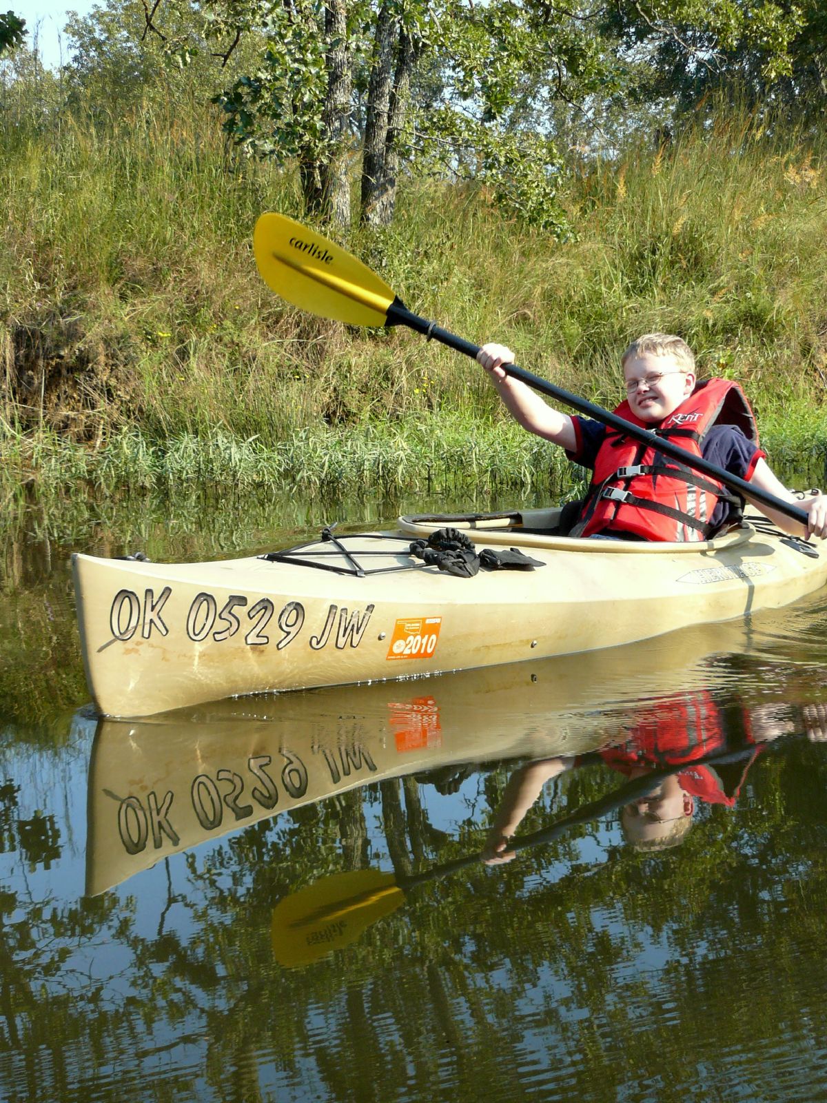 the man paddles his kayak on a calm river