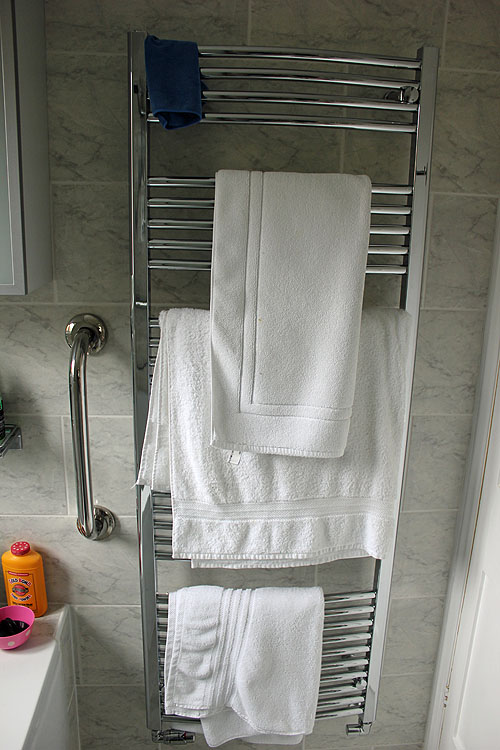 towel rack with various white towels hung on it