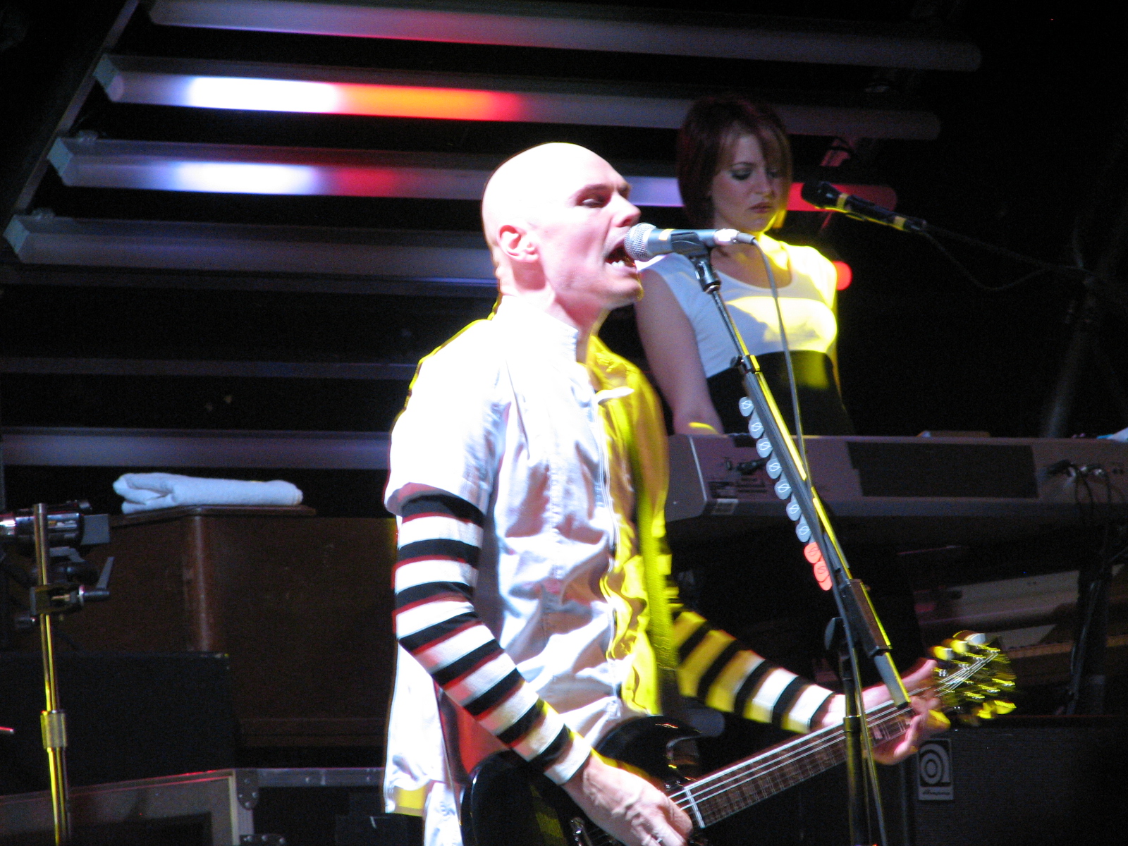 a man and woman stand on stage with microphones