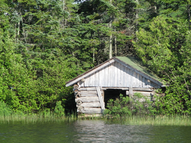 a lake house is surrounded by the trees