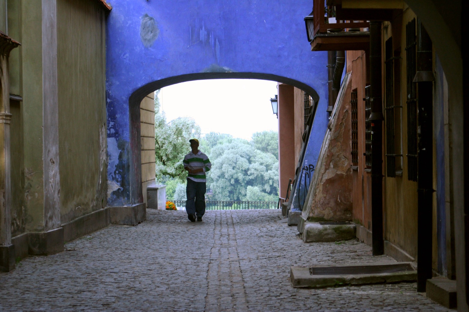 a man walking in the entrance to an alley