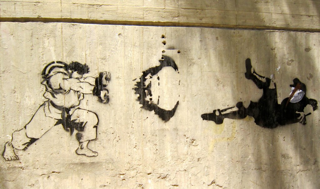 a wall with a drawing of a man kicking a woman down the street