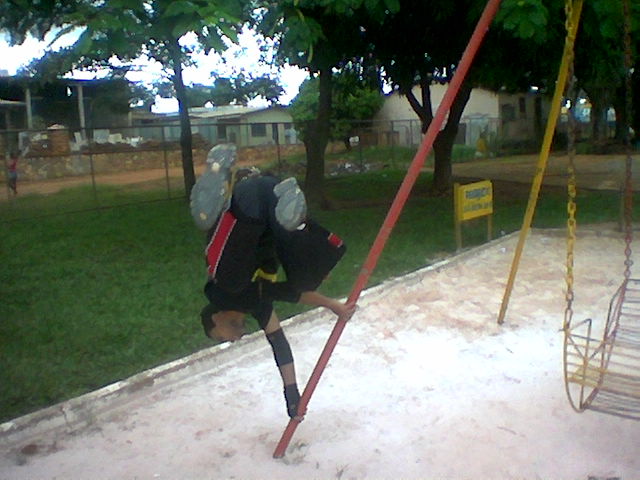 there is a boy climbing up a swing in the playground