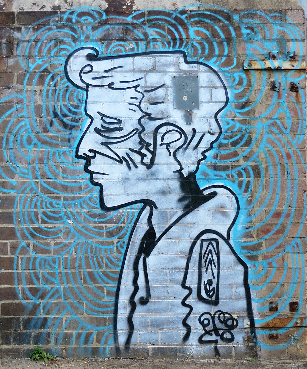 graffiti painted on the side of a brick wall depicting a boy in a hat and tie