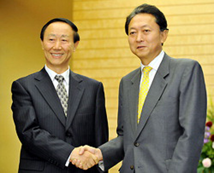 two men shaking hands in front of a podium
