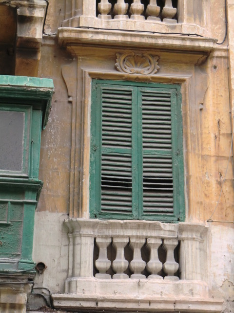 an old building has green window shutters