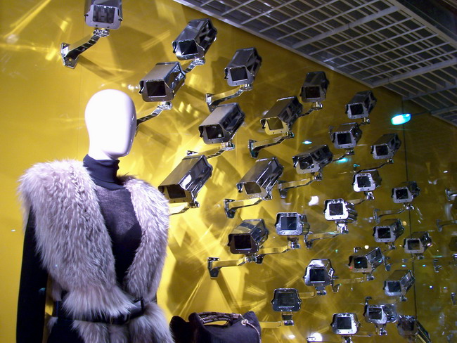 a mannequin with lots of silver objects hanging on the wall