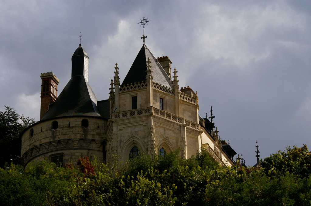 a large brown castle on top of a green hillside