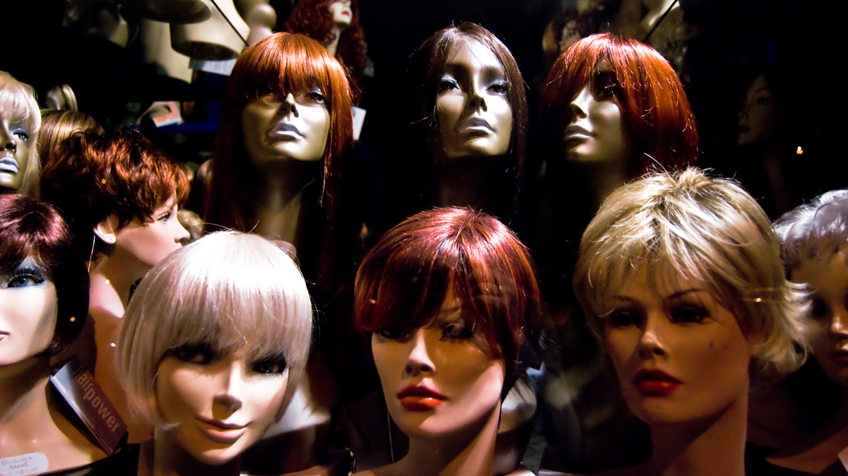 mannequin heads are lined up against a black background